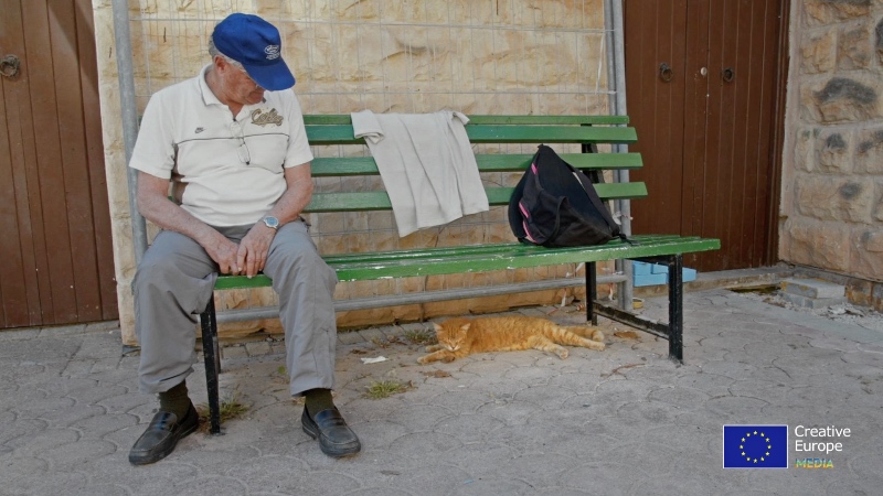 cat and elderly man on a bench