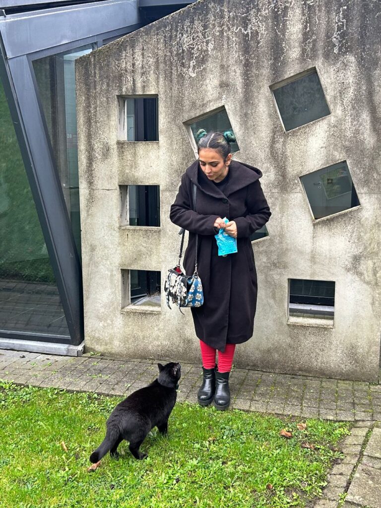 Aristide, the black cat of the folk museum in Bruges with one of the members of his cat team